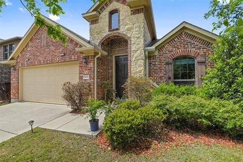 the front of a brick house with a garage door